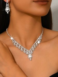 Primer plano de conjunto de joyas nupciales con cristales de lágrima y collar en forma de V
