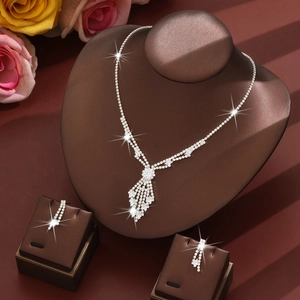 Detailed view of silver-toned rhinestone bridal jewelry set with tassel fringe on a neck bust