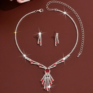 Detailed view of rhinestone necklace and earring set with red teardrop gemstones