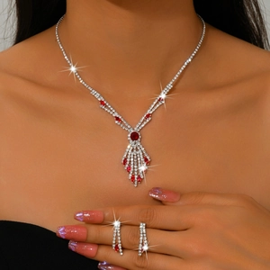 Macro shot of silver bridal necklace and earrings set with red gems and sparkling rhinestones