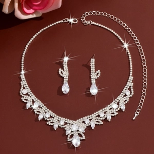 Détail de parure mariage en strass avec collier et boucles d'oreilles sur fond rouge