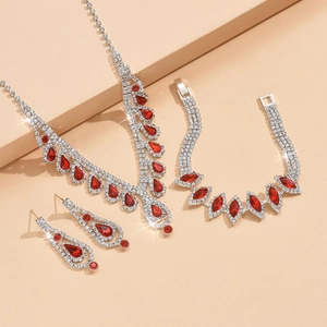 Detalle de un conjunto de joyas de novia plateadas con cristales rojos de gota