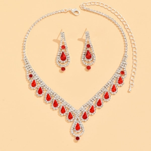 Detalle de conjunto de joyas para novia con gemas rojas y brillantes cristales