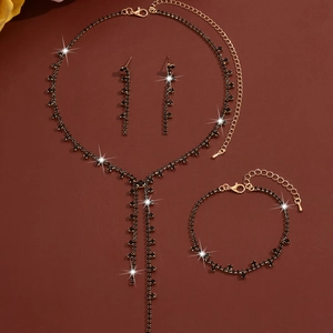 Detailed set of gold plated necklace, bracelet, and drop earrings with black rhinestones