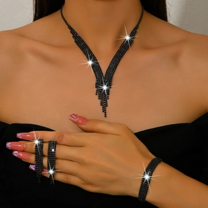 Detalle del conjunto de joyas de pedrería negra brillante con collar de borlas y brazalete