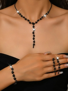 Detail of elegant black crystal jewelry set with sparkling Y-shaped necklace and bracelet