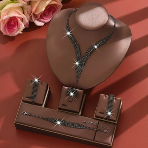 Vista detallada del collar de flecos de diamantes negros y set de joyas expuesto