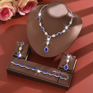 Detail of luxury silver jewelry set with pear-shaped blue crystals and white zircons