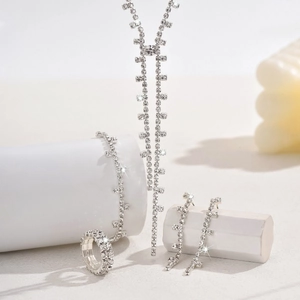 Detail view of silver rhinestone jewelry set with tassel necklace, bracelet and earrings