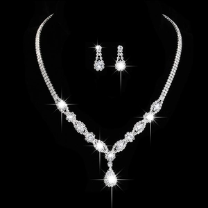 Dettaglio macro del set da sposa argento con zirconi a goccia e strass scintillanti su nero
