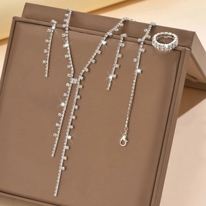 Detailed close-up of a silver rhinestone jewelry set with necklace and earrings