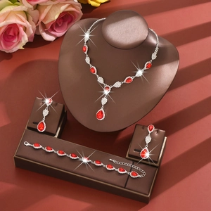 Macro detail of ruby red teardrop jewelry set with necklace and earrings on leather tray