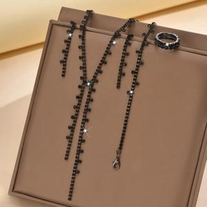 Detail of luxury jewelry set featuring black rhinestone long fringe necklace and earrings