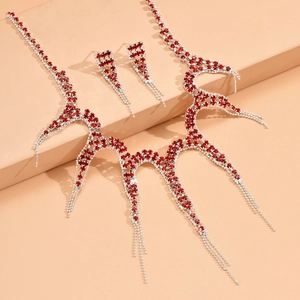 Primer plano de collar de pulpo plateado y pendientes con brillantes rojos y flecos