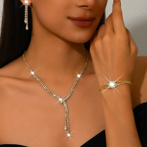 Three-piece jewelry set with shimmering tassel necklace, bracelet and earrings in gold finish