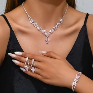 Detailed view of bridal pink rhinestone necklace and earring set on a model