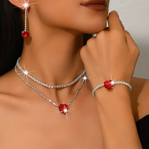 Sparkling silver jewelry set with red heart stones and diamond chains on a female model