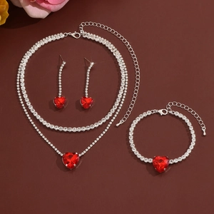 Detailed view of rhinestone jewelry set with red heart crystals on a dark background