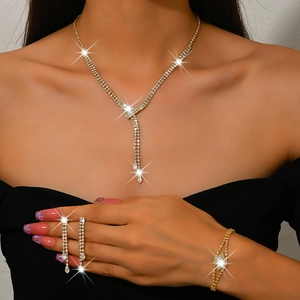 Close-up of luxury gold-tone bridal jewelry set with sparkling rhinestones on a model