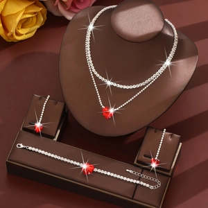 Close-up of sparkling heart-shaped ruby necklace set on a brown display stand