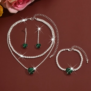 Detail of silver jewelry set with green heart gemstones and sparkling rhinestones
