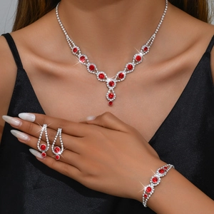 Close-up of red and clear rhinestone jewelry set with necklace, bracelet and earrings