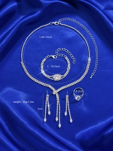 Detail view of silver rhinestone jewelry set with tassel earrings on blue silk background