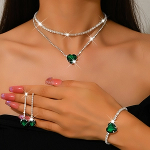 Detail shot of a dark green heart-shaped jewelry set with necklace, earrings, and bracelet