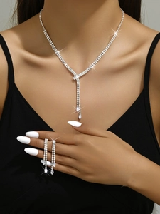 Close-up of sparkling bridal jewelry set with fringe necklace and dangling earrings