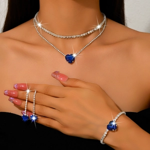 Detailed view of model wearing a double-layered blue heart necklace and matching earrings