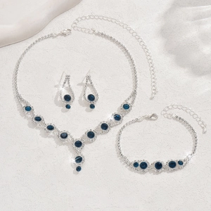 Detailed view of silver necklace and earrings set featuring radiant blue rhinestones