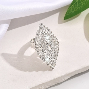 Primer plano de anillo plateado en forma de hoja con pedrería sobre base de piedra