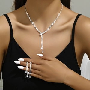 Close-up of sparkling silver tassel necklace and drop earrings on a female model
