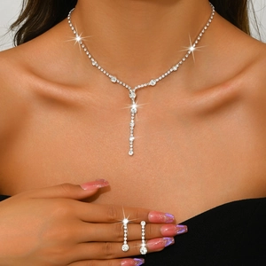 Close-up of elegant silver necklace and drop earrings set with sparkling zircon stones