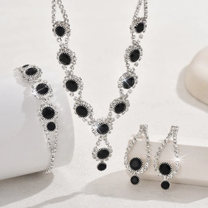 Elegant bridal jewelry set with round black gems and sparkling crystals on white stone