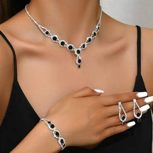 Detailed view of elegant silver jewelry set with black oval crystals on a female model