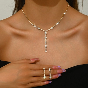 Close-up of golden jewelry set with sparkling zircon necklace and matching earrings