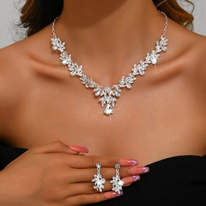 Silver bridal jewelry set featuring vine leaf necklace and teardrop rhinestone earrings