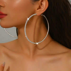 Close-up of model wearing large 8cm silver hoop earrings with sparkling rhinestones