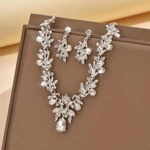 Macro shot of bridal silver necklace set with teardrop crystals and floral leaves detail