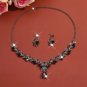 Detail of bridal jewelry set featuring black teardrop crystals and silver leaf patterns