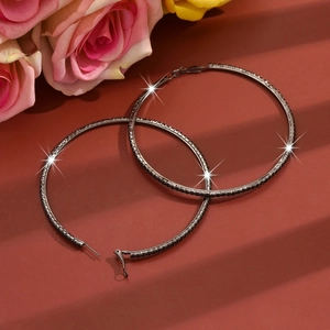 Macro shot of large gunmetal hoop earrings with shimmering black pavé rhinestones