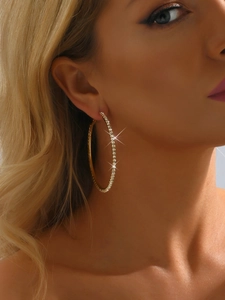 Close-up of model wearing large 8cm gold hoop earrings with sparkling rhinestones