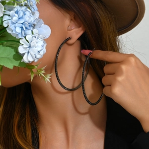 Chic 8cm gunmetal hoop earrings with black sparkling crystals on a fashion model