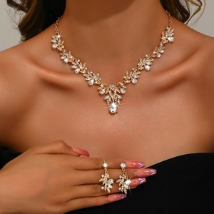 Elegant bridal jewelry set with gold necklace and earrings featuring leaf shaped crystals
