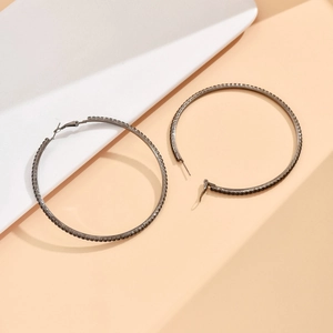 Close-up of 8cm gunmetal hoop earrings featuring meticulously set dark rhinestones