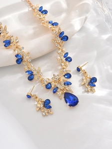 Detailed view of bridal necklace and earrings set with blue teardrop rhinestones