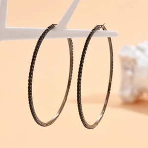 Macro shot of black plated hoop earrings featuring micro-pave black cubic zirconia stones