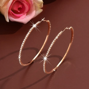 Detail of rose gold oversized hoop earrings with shimmering cubic zirconia pave setting