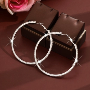 Close-up of 8cm silver oversized hoop earrings with sparkling crystals on jewelry box